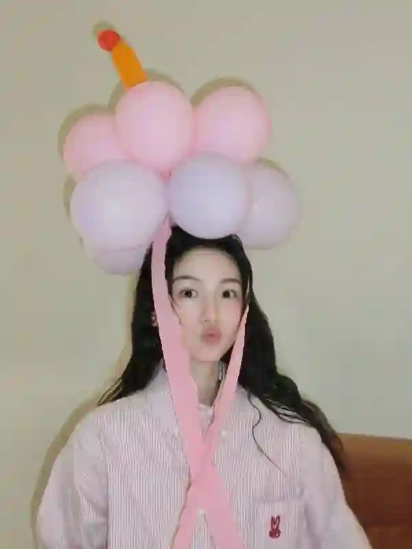 周也身着粉色条纹衬衫，头戴气球宛如梦幻少女