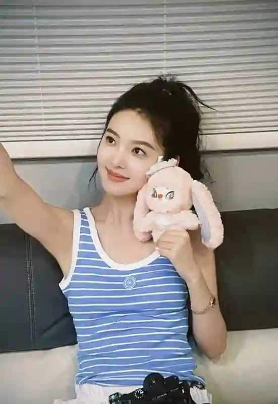 章若楠吊带造型尽显夏日活力，手捧粉色玩偶灵动吸睛