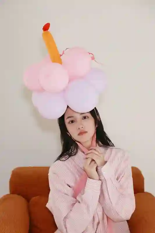 周也身着粉色条纹衬衫，头戴气球宛如梦幻少女