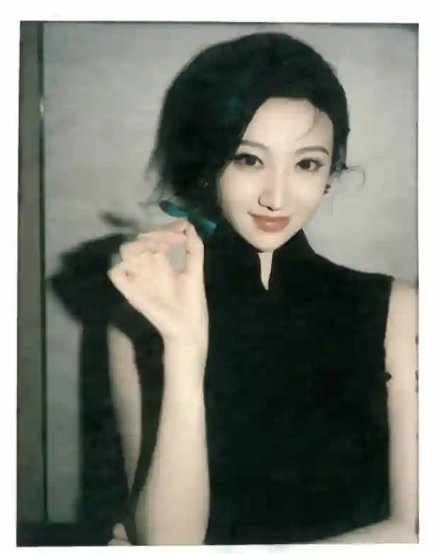 景甜黑色无袖旗袍裙撕拉片，头戴大红花演绎复古明艳风
