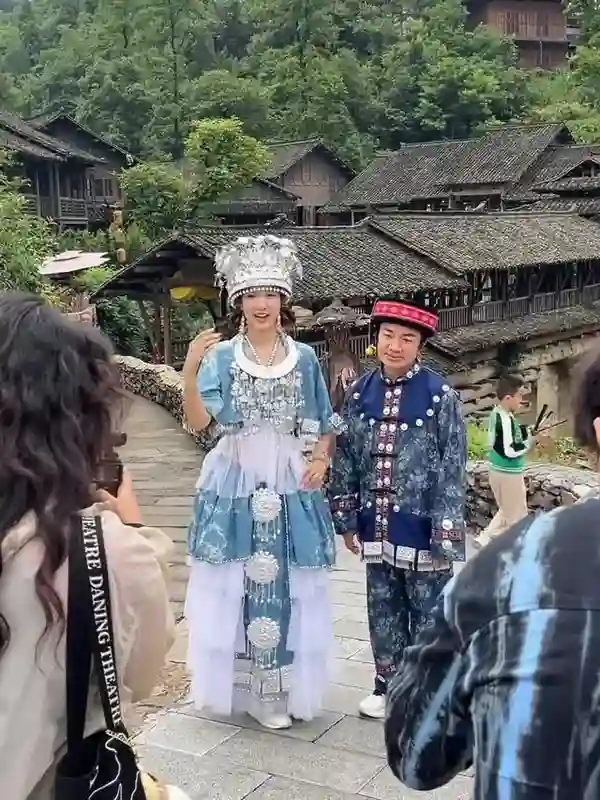 王祖蓝与李亚男在乌江，身穿苗族服装拍摄，王祖蓝一脸无奈的感觉