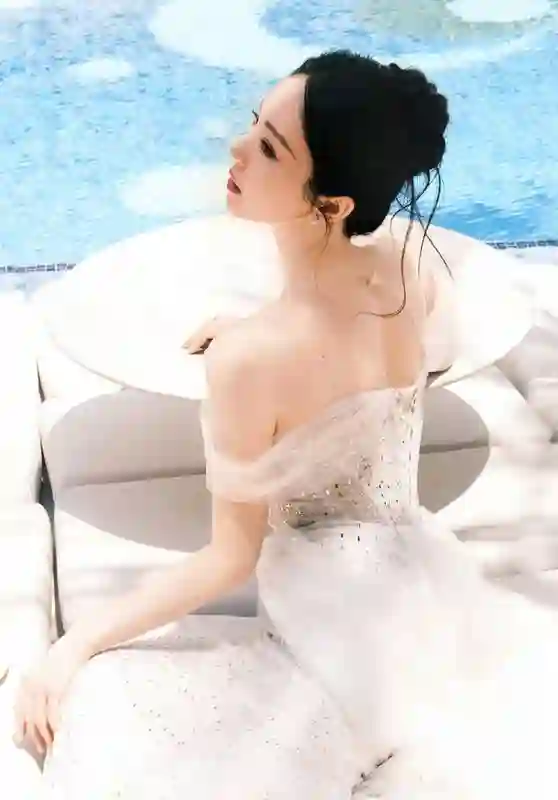 董璇泳池畔饮椰水笑容灿烂，一袭礼裙勾勒曼妙身姿尽显惬意