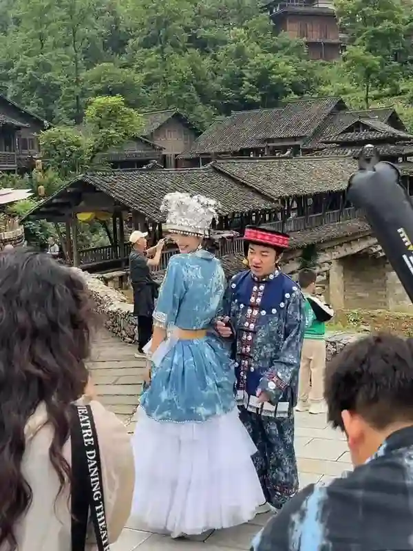 王祖蓝与李亚男在乌江，身穿苗族服装拍摄，王祖蓝一脸无奈的感觉