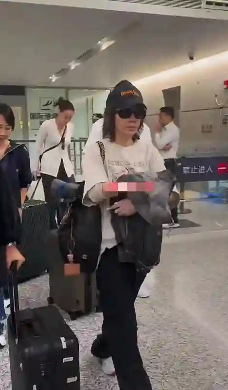 刘嘉玲机场素颜照曝光，暗沉蜡黄肌肤反差大，全程黑脸显不自信