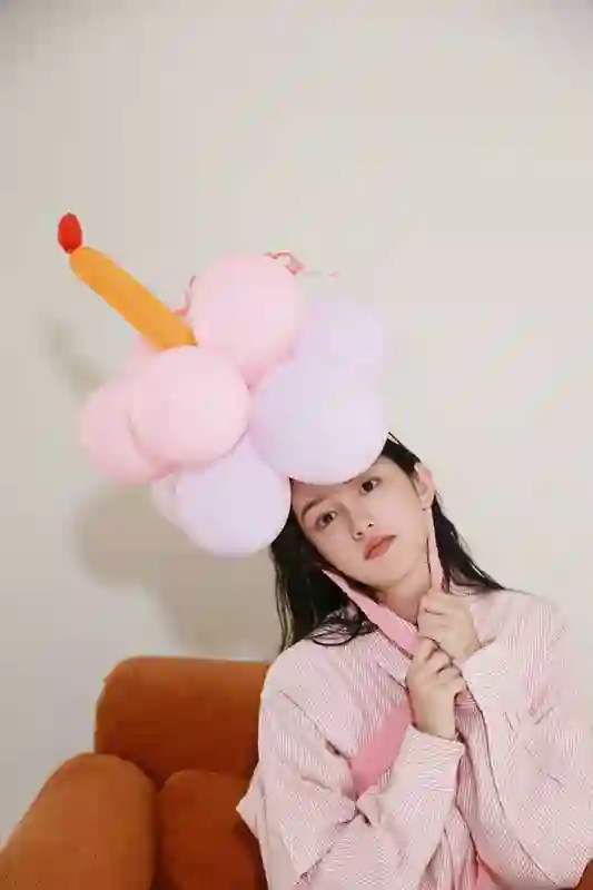 周也身着粉色条纹衬衫，头戴气球宛如梦幻少女