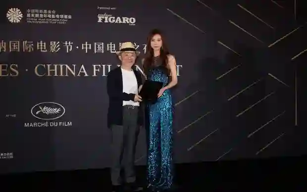 林志玲身着蓝色亮片裙躺卧礁石，如美人鱼般演绎秘境中的温柔诱惑