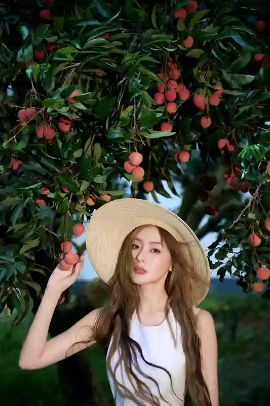 张天爱荔枝园美拍：穿白裙戴草帽，畅享田园惬意风情