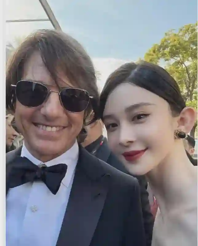 62岁阿汤哥和34岁赵樱子握手，阿汤哥一脸褶子，赵樱子姿态卑微