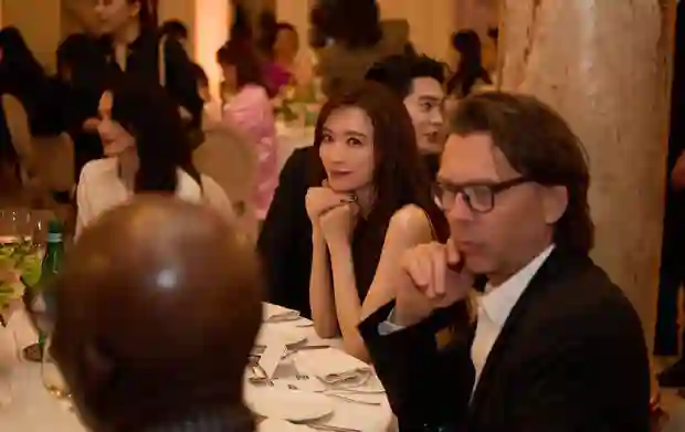 林志玲身着蓝色亮片裙躺卧礁石，如美人鱼般演绎秘境中的温柔诱惑