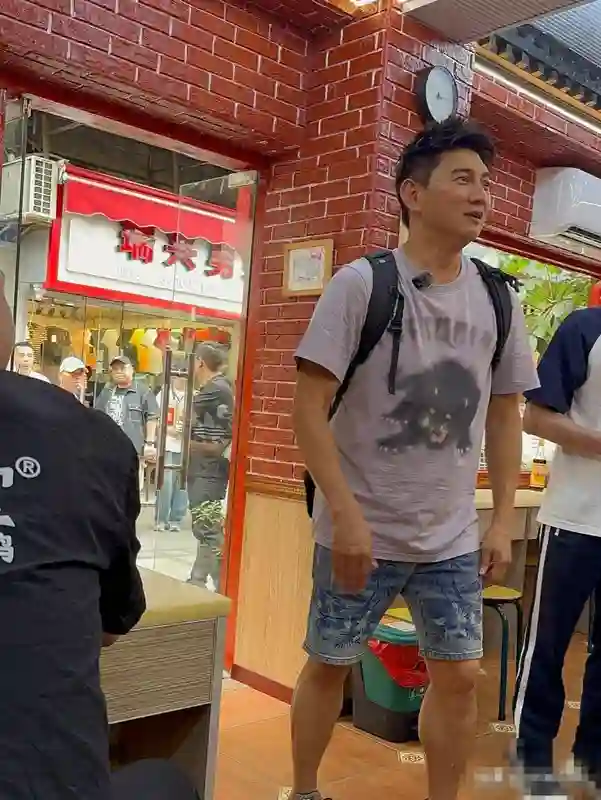 54岁吴奇隆街头被偶遇，脸肿发福有肚腩，与女粉合照时小动作亮了