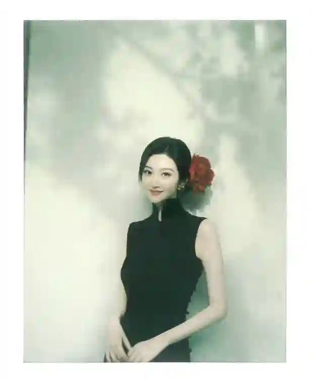 景甜黑色无袖旗袍裙撕拉片，头戴大红花演绎复古明艳风