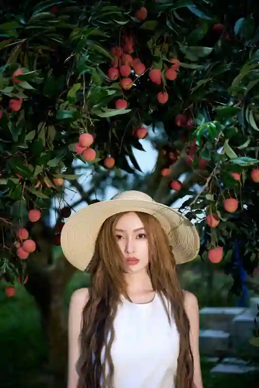 张天爱荔枝园美拍：穿白裙戴草帽，畅享田园惬意风情