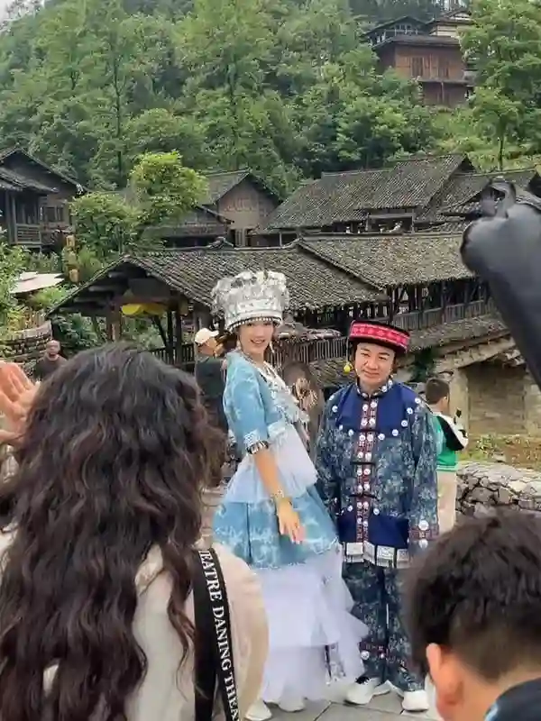 王祖蓝与李亚男在乌江，身穿苗族服装拍摄，王祖蓝一脸无奈的感觉